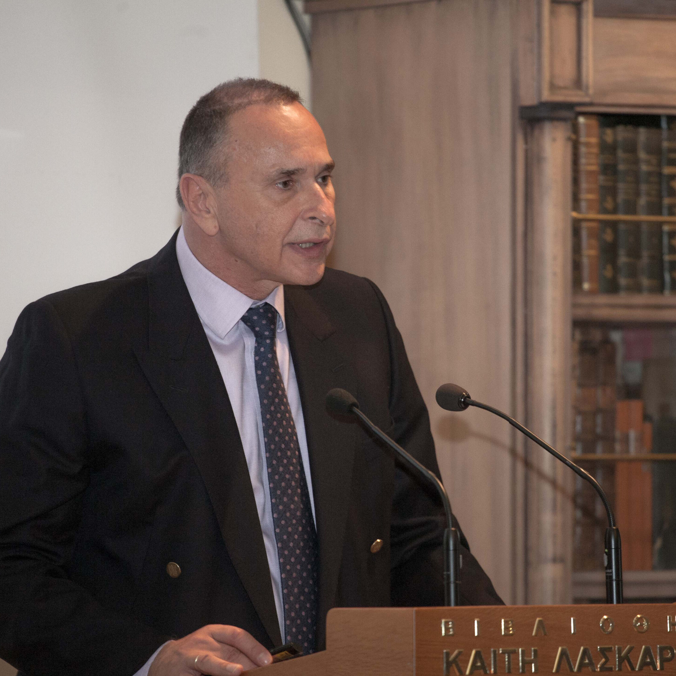 Author profile pic of Athanasios Platias in a dark-coloured suit, standing at a podium as if giving a speech