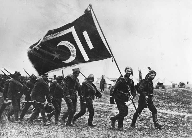 Turkish troops follow a standard bearer carrying the Turkish flag across a muddy field, circa 1917. (Photo: Hulton Archive/Getty Images)