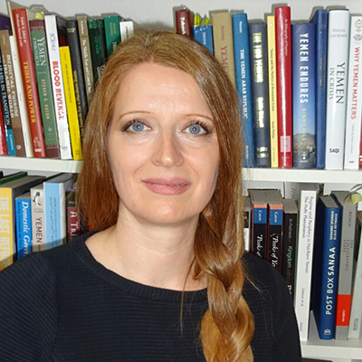 Marieke Brandt author photo in front of books