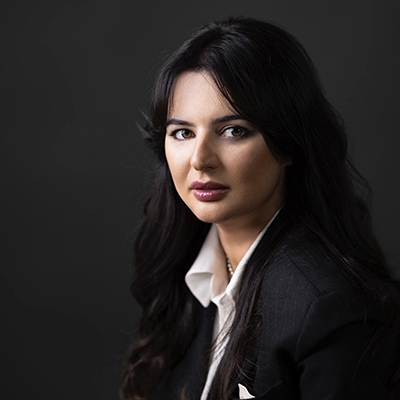 Profile headshot of Natia Seskuria showing the author looking at the viewer with a dark background.